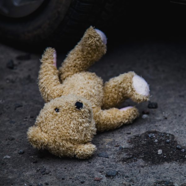 Concept: lost childhood, loneliness, pain and depression. Teddy Concept: lost childhood, loneliness, pain and depression. Teddy bear lying down outdoors.